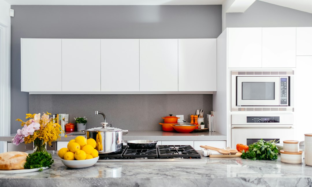 Cocina moderna blanca con isla y cubierta clara